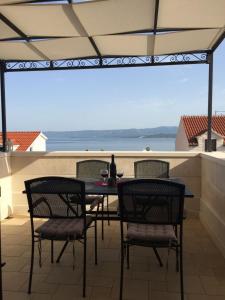 a table and chairs on a patio with a view of the ocean at Apartment Nikola M in Bol