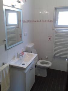 a white bathroom with a sink and a toilet at Apartment Nikola M in Bol