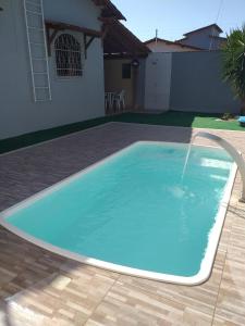 una gran piscina azul con una fuente en un patio en Casa Praia Grande, en Nova Almeida