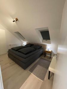 a bedroom with a black bed in a attic at Auszeit Offenburg in Offenburg