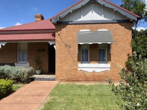a brick house with a window and a porch at Merala a cosy cottage with easy stroll to CBD in Mudgee