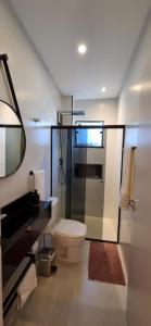 a bathroom with a toilet and a mirror at APTO NOVO - Praias, Beto Carrero e Aeroporto in Navegantes