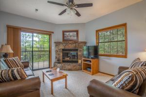 Una sala de estar con sofás, televisión y chimenea. en 2BR Village At Indian Point 1004 near SDC-Free Tickets Daily up to $500, en Branson