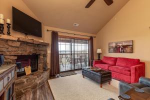 a living room with a red couch and a fireplace at 2BR+Loft Village At Indian Point 1509 near SDC- Free Tickets Daily up to $500 in Branson