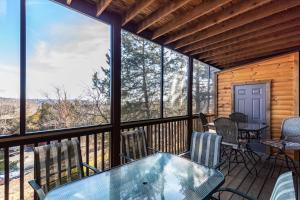 eine abgeschirmte Veranda mit einem Tisch und Stühlen in der Unterkunft 2BR Village At Indian Point 903 near SDC-Free Tickets Daily up to $500 in Branson