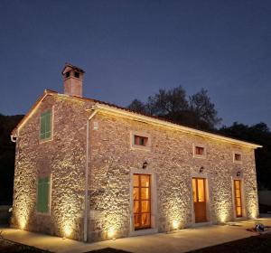 un viejo edificio de piedra con luces de Navidad en él en Casa Škitaconka, en Koromačno
