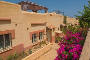 a building with pink flowers in front of it at Sea views and hot tub close to beach in La Cala de Mijas