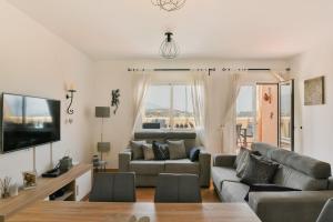 a living room with a couch and a tv at Sea views and hot tub close to beach in La Cala de Mijas