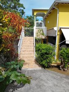 a stairway leading to a yellow house at Haut de Villa LA FLEUR DE CANNE in Lamentin