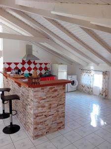 a kitchen with a red counter in a room at Haut de Villa LA FLEUR DE CANNE in Lamentin