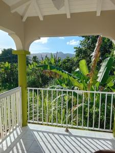 a balcony with a view of the jungle at Haut de Villa LA FLEUR DE CANNE in Lamentin