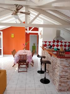 a kitchen and dining room with a table and chairs at Haut de Villa LA FLEUR DE CANNE in Lamentin