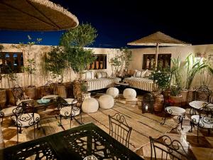 a patio with couches and tables and chairs at Dar Yamna Maison d'Hôtes in El Gouassem