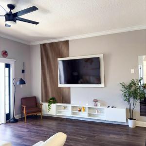 キシミーにあるThemed Luxury Apartment With Pools and Jacuzziの壁に薄型テレビが取り付けられたリビングルーム