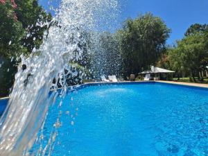 a fountain in the middle of a swimming pool at Posada Del Sol - Complejo de Cabañas in Junín