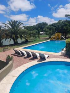 a swimming pool with a bunch of chairs around it at Posada Del Sol - Complejo de Cabañas in Junín