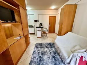 a room with a bed and a tv and a kitchen at Vila da Serra,1min Biocor in Nova Lima