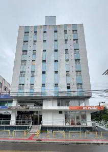 a tall building with a staircase in front of it at Loft Studio no Kobrasol in São José