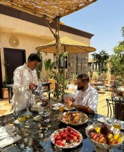 two men sitting at a table with food at Dar Yamna Maison d'Hôtes in El Gouassem +15 photos