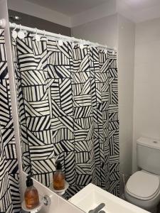 a bathroom with a black and white shower curtain at Roma in Belén de Escobar +5 photos
