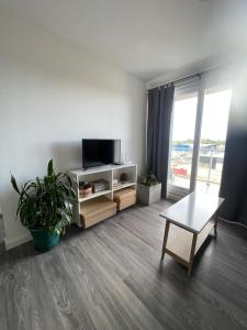 a living room with a flat screen tv and a table at Roma in Belén de Escobar