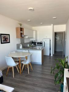 a kitchen with a table and chairs and a refrigerator at Roma in Belén de Escobar