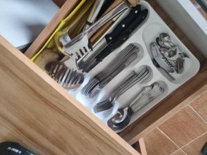 a drawer full of kitchen utensils in a cabinet at Apartamento Centro Guarapari in Guarapari