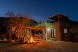 a fire pit in front of a house at night at Rancho Ecológico Sol De Mayo in Romerillal