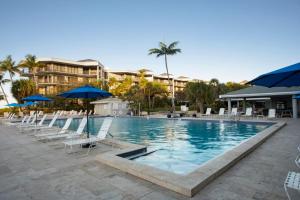 a large swimming pool with chairs and umbrellas at Tranquility by the Beach in Key West