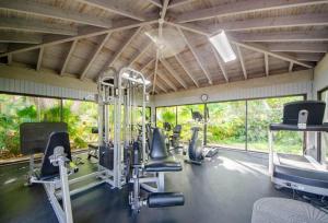 a gym with treadmills and exercise equipment and windows at Tranquility by the Beach in Key West
