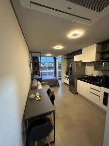 a kitchen and living room with a couch and a table at Charmoso Loft em Resort in Xangri-lá