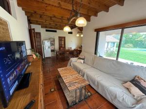 a living room with a couch and a flat screen tv at Carmela Inn in Monte Grande +11 photos