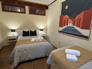 a bedroom with two beds and a painting on the wall at Carmela Inn in Monte Grande