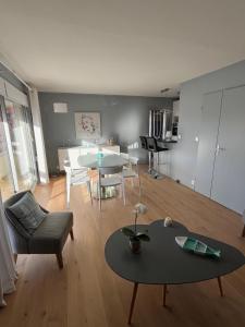 ein Wohnzimmer mit Sofa und Tisch in der Unterkunft Les Glycines in Le Touquet-Paris-Plage