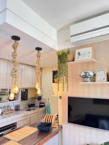 a kitchen with a large tv and a table at Aldeia das Águas Park Resort - Flat B309 Quartier in Barra do Piraí