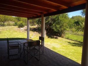 a patio with a table and chairs on a porch at Agua de Oro antistress cabana in Agua de Oro