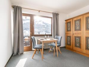a dining room with a table and chairs and a window at Brixen Alpin Living Top 9 und 10 in Brixen im Thale