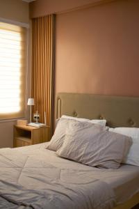 Un dormitorio con una gran cama blanca con ventana. en Marina Spatial Studio Condo Unit, en Dumaguete