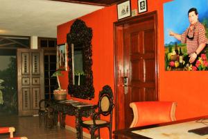 a room with an orange wall with a table and a mirror at La Posada del Arcangel in Managua