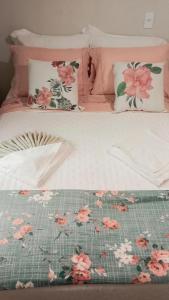 a bed with pink and white sheets and flowers on it at Palmenhaus in Pomerode