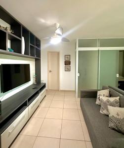 a living room with a couch and a flat screen tv at Costazul Confort Flats in Rio das Ostras +3 photos