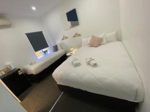 a hotel room with two beds with white sheets at Central Motel Mudgee in Mudgee