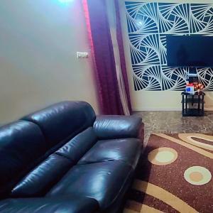 a black leather couch in a living room at Appartement trois chambres salon in Saint-Louis