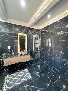 a bathroom with black marble walls and mirrors at Villa Marrakech piscine in Marrakech