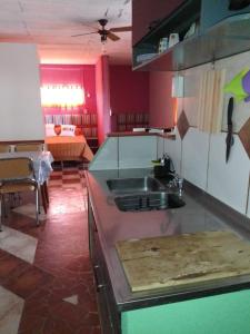 a kitchen with a sink and a table in a room at Alodelrafa in San Lorenzo