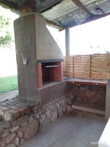 an outdoor pizza oven sitting on top of a stone wall at Alodelrafa in San Lorenzo