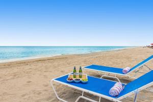 a picnic table on the beach with beers and snacks at Infinite View Balcony - Amazing Pool - Gym in Hallandale Beach
