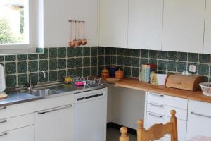 eine Küche mit weißen Schränken und einem Waschbecken in der Unterkunft Casa Angela in Locarno