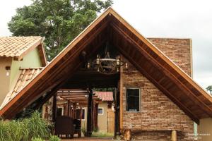 a brick house with a large wooden roof at Pousada do Vovô in Fronteira