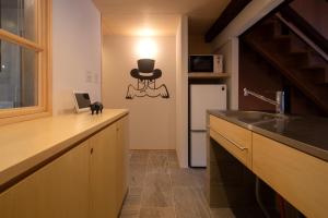 a kitchen with a top hat on the wall at MINKA Riverside Villas in Shimminato